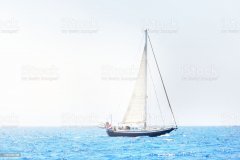 Elegant dutch cruising yacht sailing in a still water of an open Mediterranean sea on a clear day. Idyllic seascape. Summer vacations, leisure activity, sport and recreation, private wessel